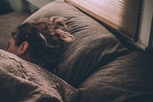 Woman sleeping peacefully on her side under soft blankets