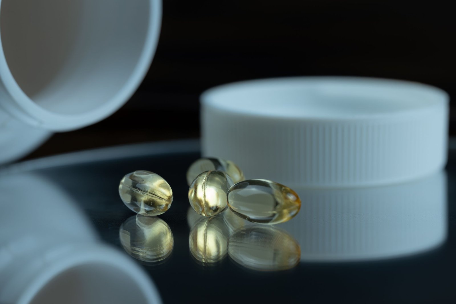 Soft gel supplement capsules beside a white bottle cap, illustrating magnesium glycinate for sleep